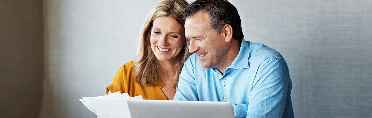 A happy couple reviews their dental invoices.