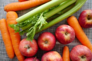 Carrots, celery and apples on a tabletop