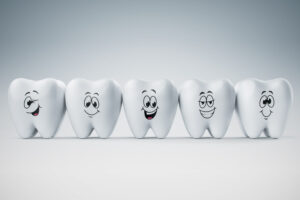 A model of five teeth with happy faces.