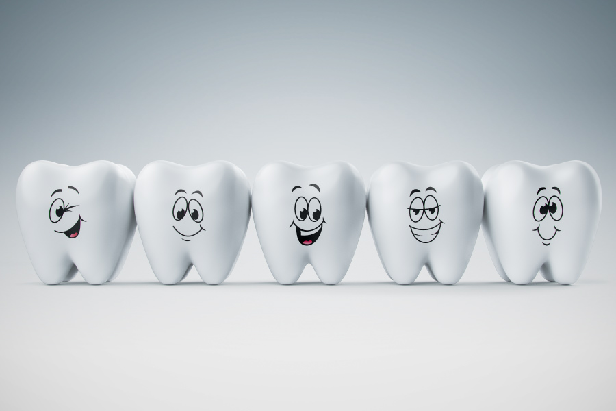 A model of five teeth with happy faces.