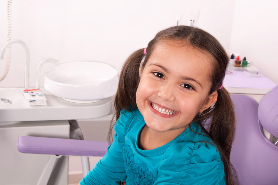 Smiling young girl in the dental chair