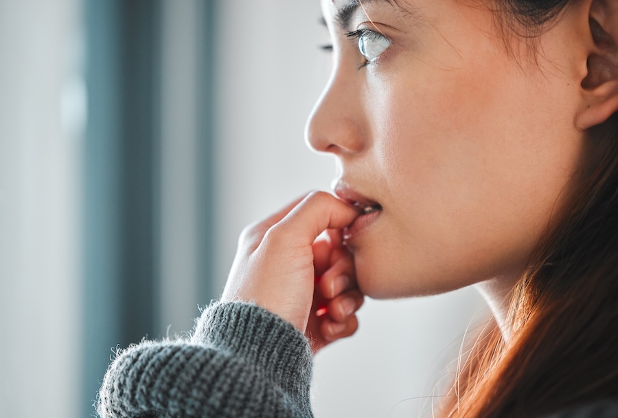 woman wanting to stop nail biting, an oral habit that can cause damage to your teeth